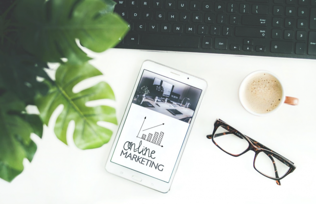 Tablet Sitting on a White Table and Showcasing Online Marketing
